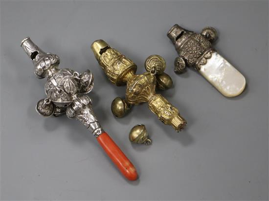A 19th century silver and coral childs rattle and whistle and two other rattles.